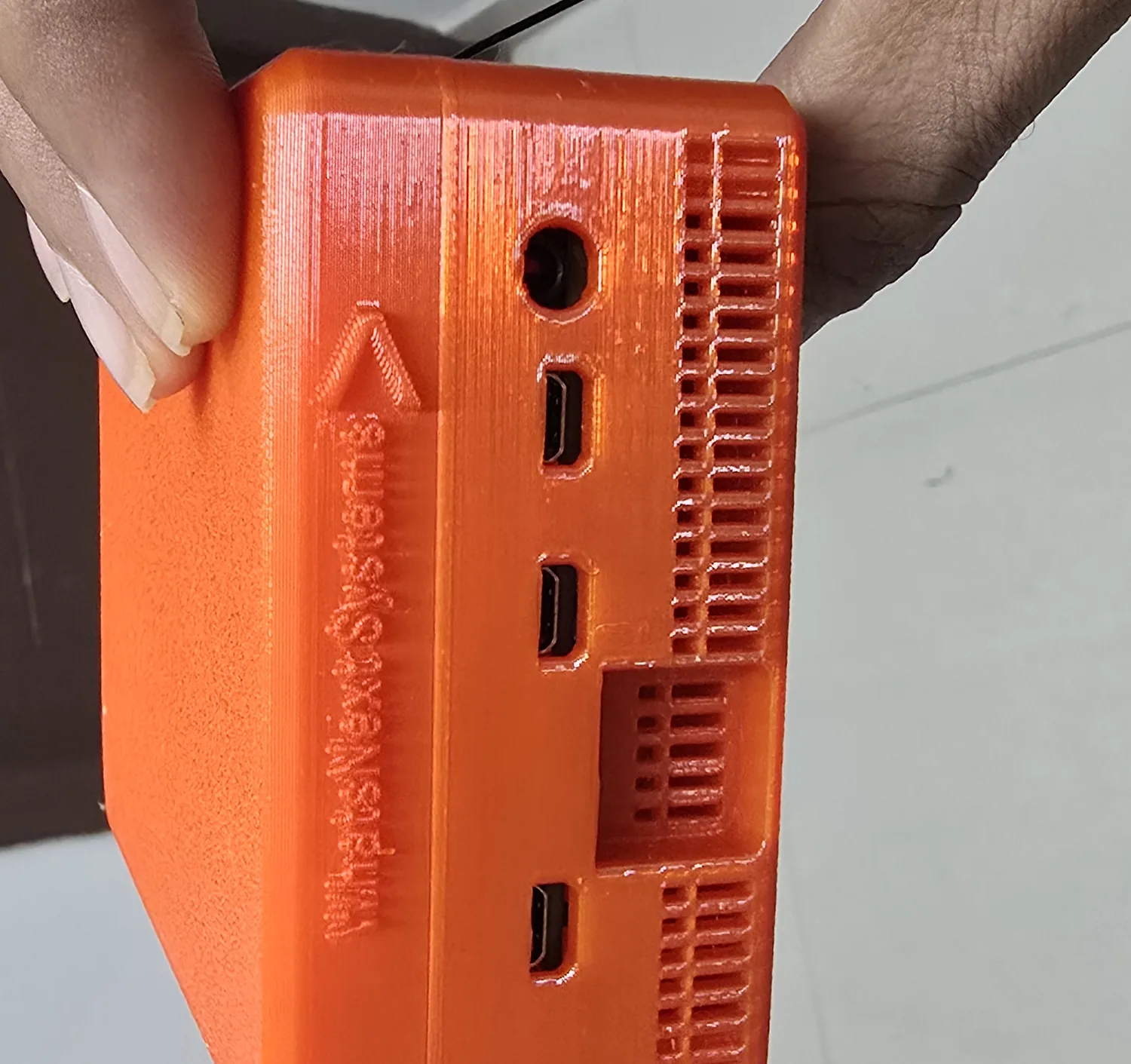 The side of the SK-01 prototype, showing its ports, cooling vents and the embossed WhatsNext Systems name.